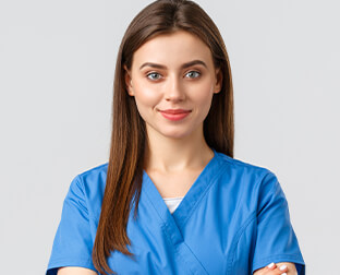 Young nurse in blue scrubs smiling confidently, representing healthcare and medical profession.