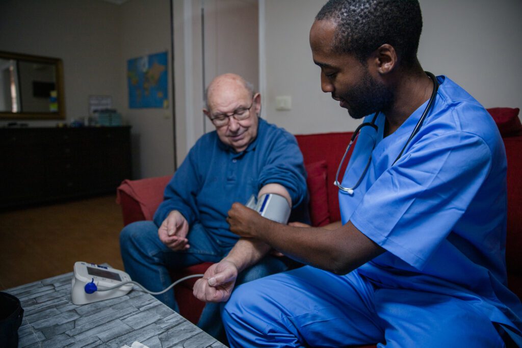 An African doctor takes the blood pressure of an elderly patient.