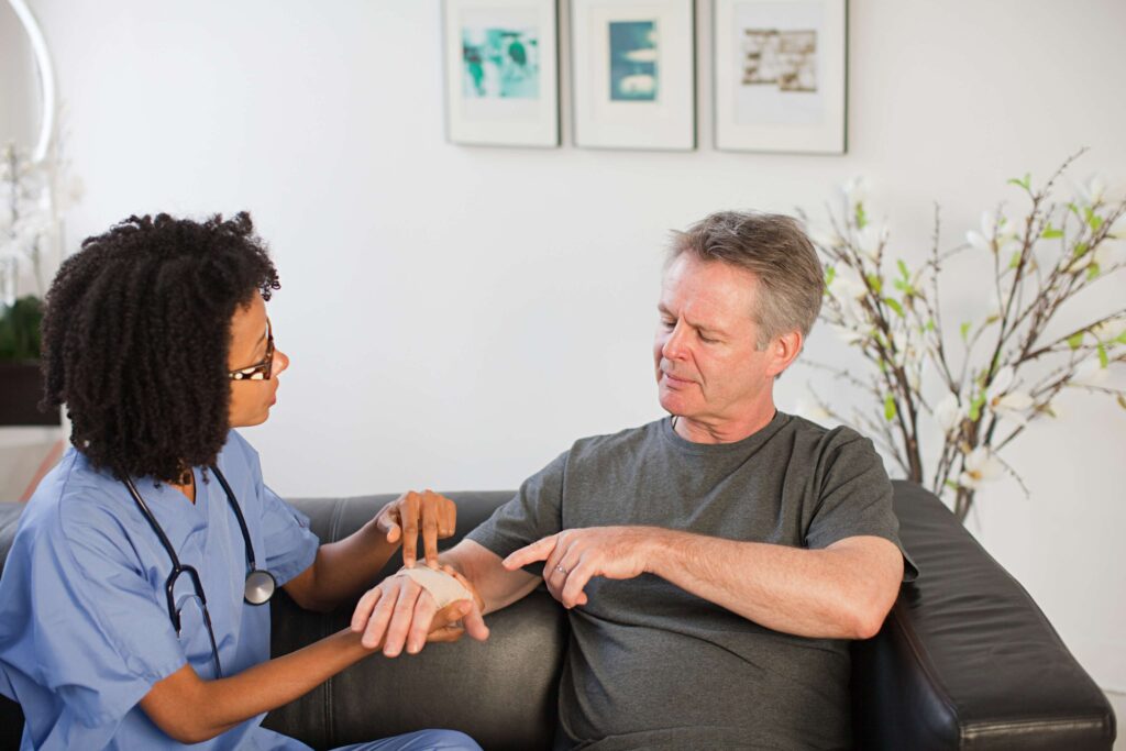 nurse-visiting-man-with-wrist-injury-2023-11-27-05-26-54-utc